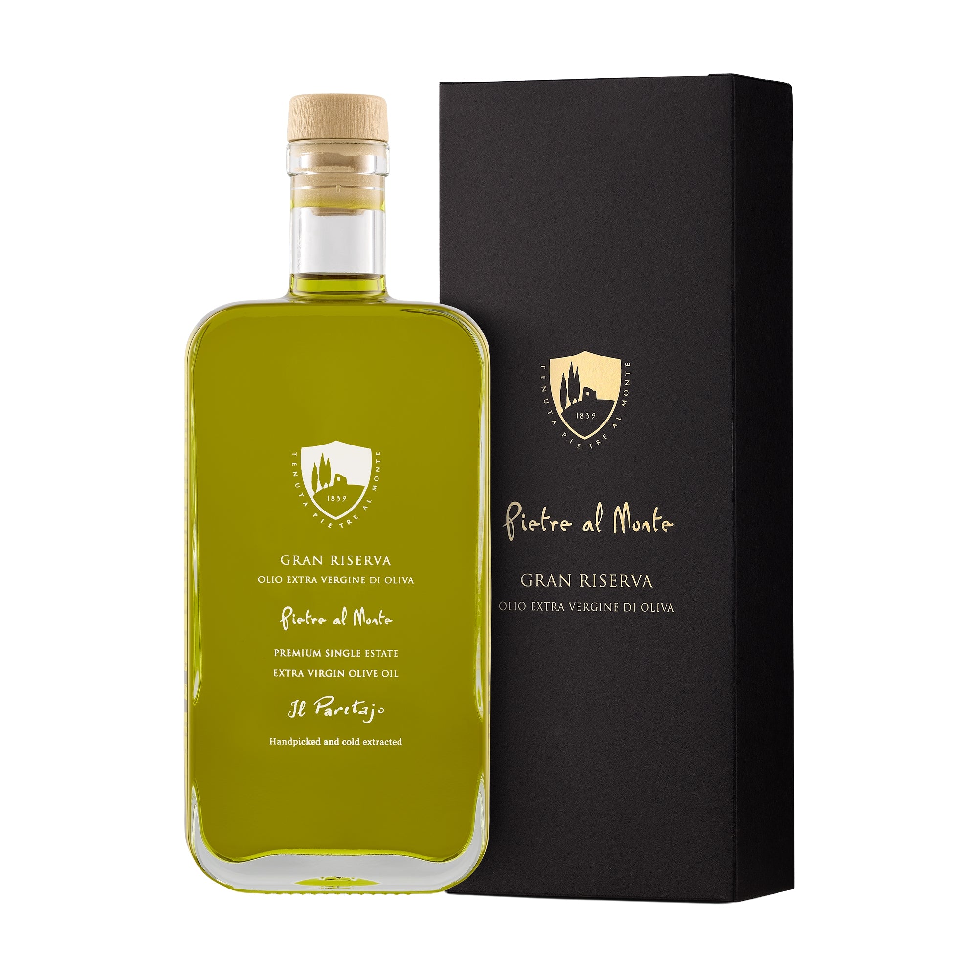 A bottle of Pietre al Monte Gran Riserva extra virgin olive oil and a clear bottle showing the green oil inside, accompanied by a black gift box with a gold emblem.